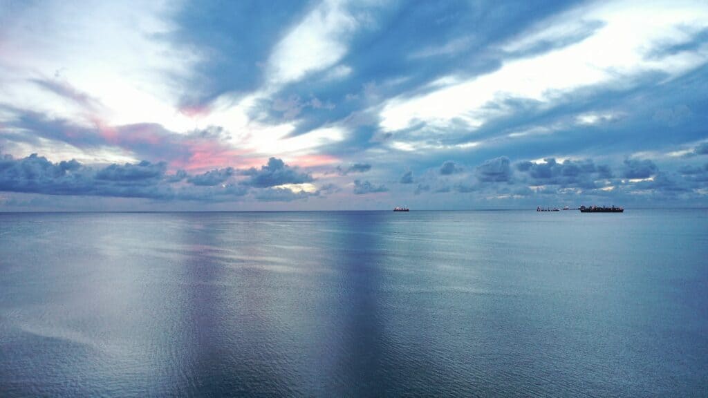 blue sea under blue sky and white clouds during daytime
